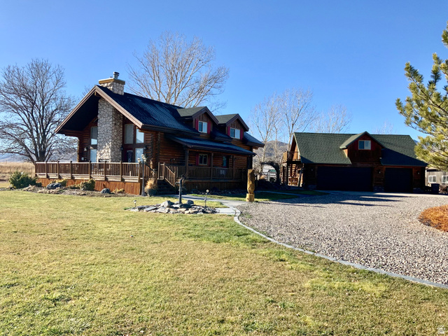 76 Highway 118 Monroe, UT 84754 - Photo 23 of 76 View of front of house with log exterior, covered porch, a front lawn, an outdoor structure, and a chimney