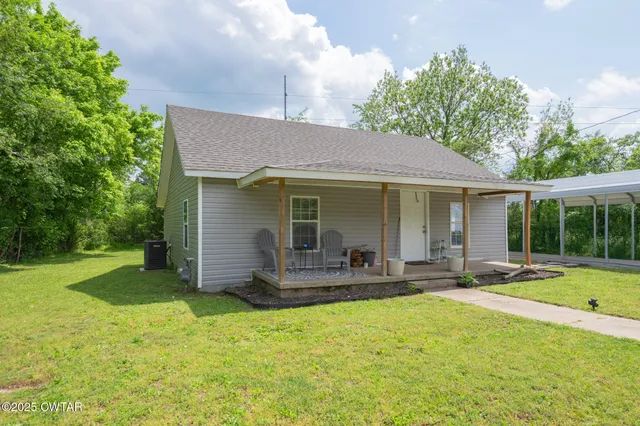 a front view of a house with a garden and patio