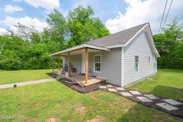 a backyard of a house with table and chairs