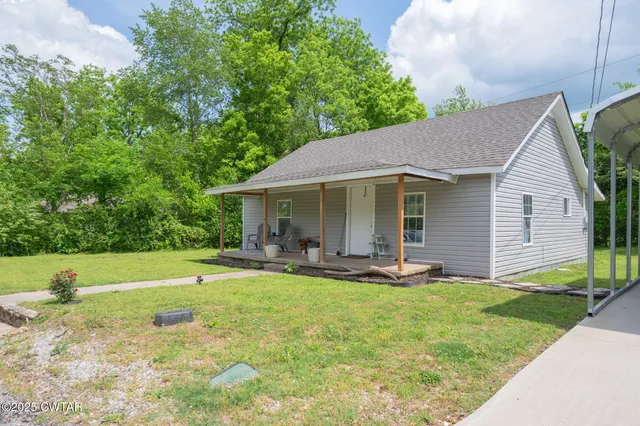 a view of a house with backyard and sitting area