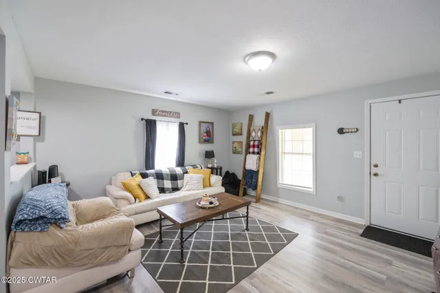 a living room with furniture and wooden floor