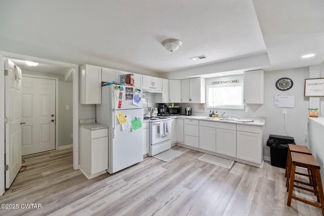 a kitchen with refrigerator and cabinets