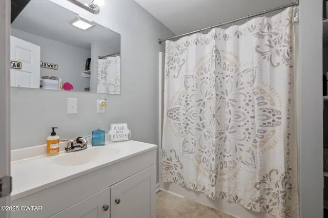 a bathroom with a shower curtain and a sink