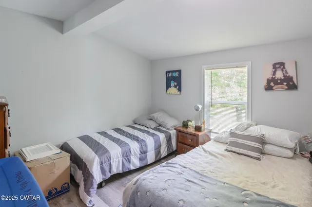 a bedroom with two beds and a window