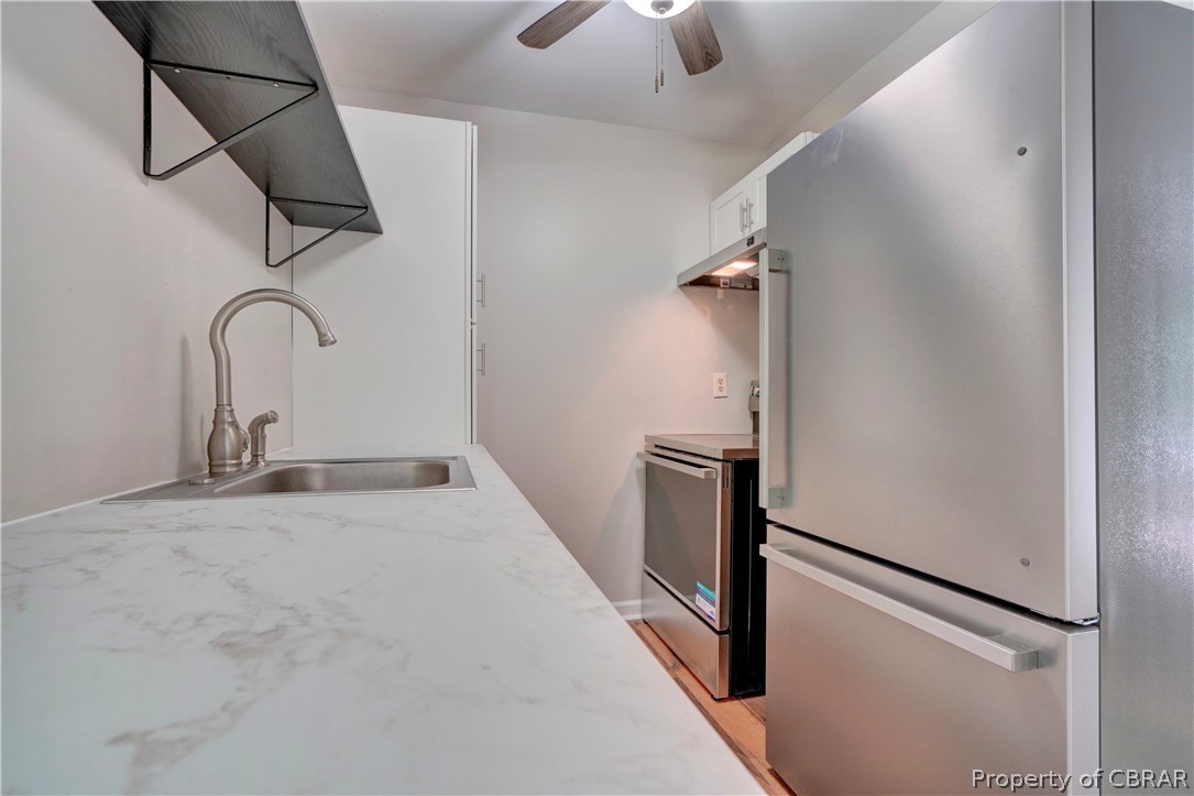 8269 Ark Road Gloucester, VA 23061 - Photo 12 of 33 Kitchen featuring ceiling fan, light hardwood / wood-style floors, stainless steel fridge, range, and sink