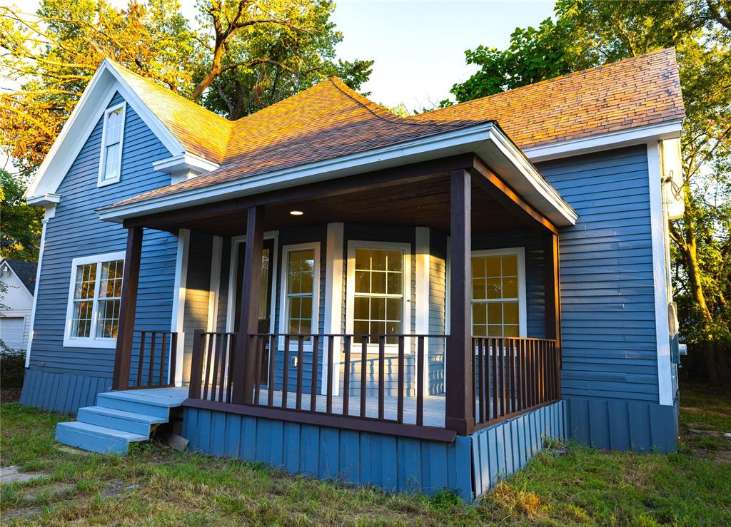 a view of brick house with a small deck