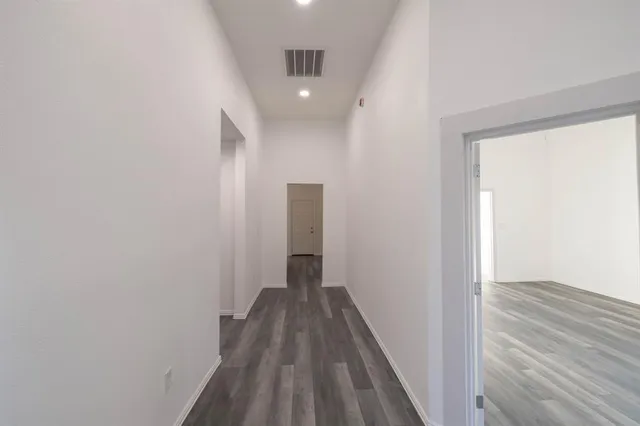a view of a hallway with wooden floor