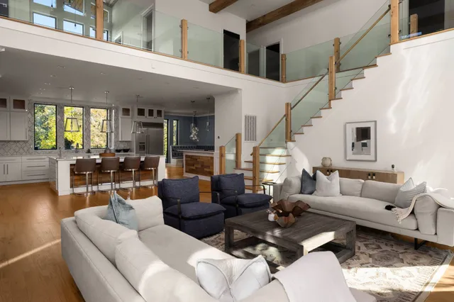 a dining hall with stainless steel appliances kitchen island granite countertop a dining table chairs and granite counter tops