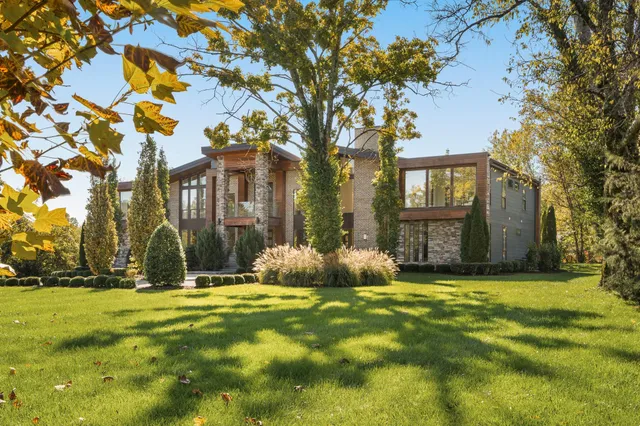 a front view of house with yard and trees around
