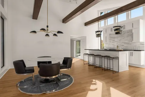 a view of a brick house with a small yard and wooden fence