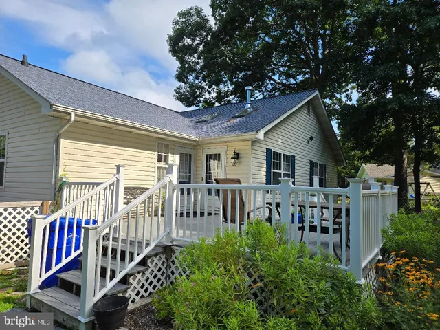 a view of a house with wooden deck and furniture