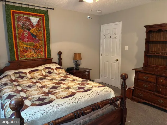 a bathroom with a granite countertop sink a toilet and mirror