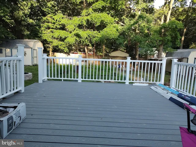 a front view of a house with a garden and trees