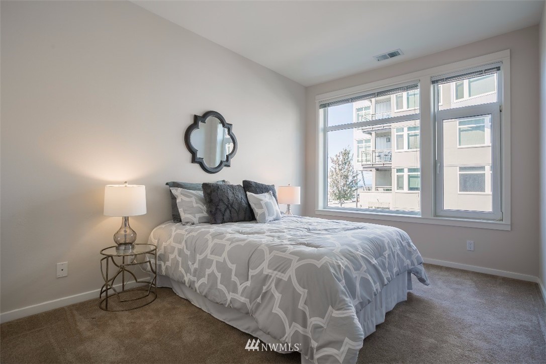 2000 Alaskan Way, Unit 257 Seattle, WA 98121 - Photo 13 of 25 a bed sitting in a bedroom next to a window