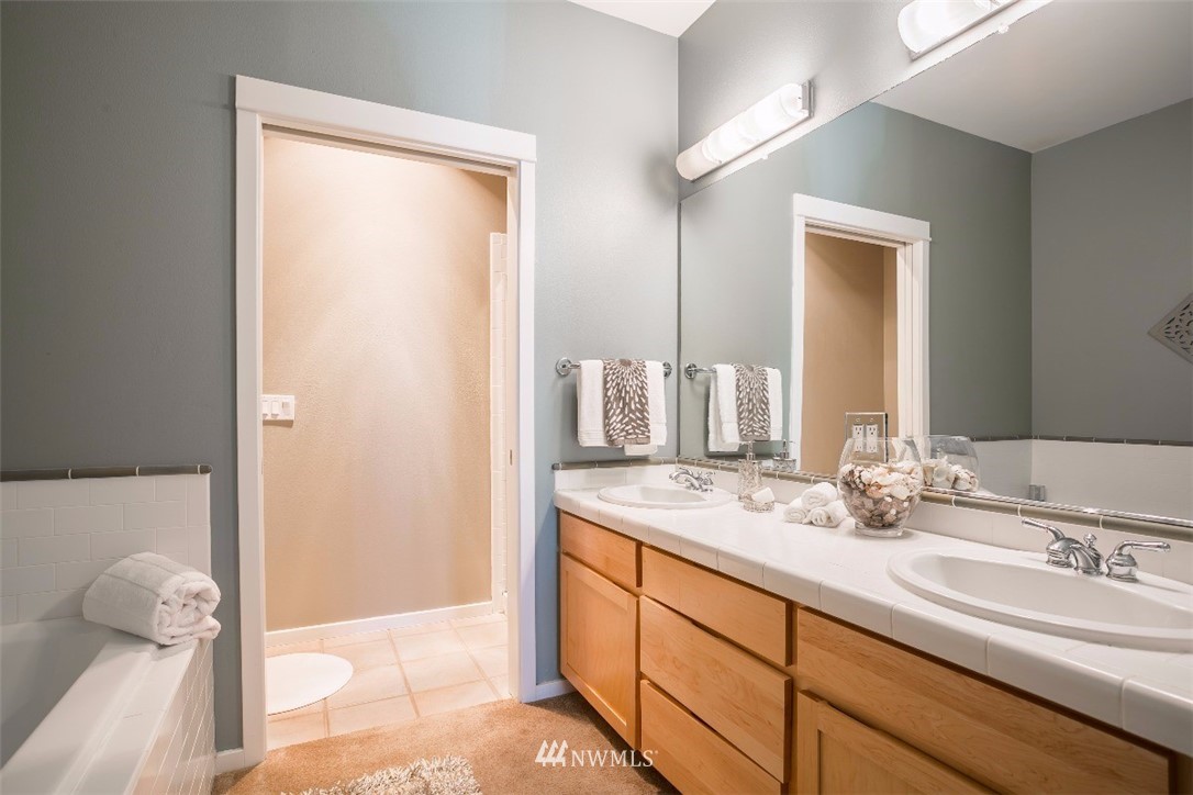 2000 Alaskan Way, Unit 257 Seattle, WA 98121 - Photo 18 of 25 a bathroom with a double vanity sink and a mirror