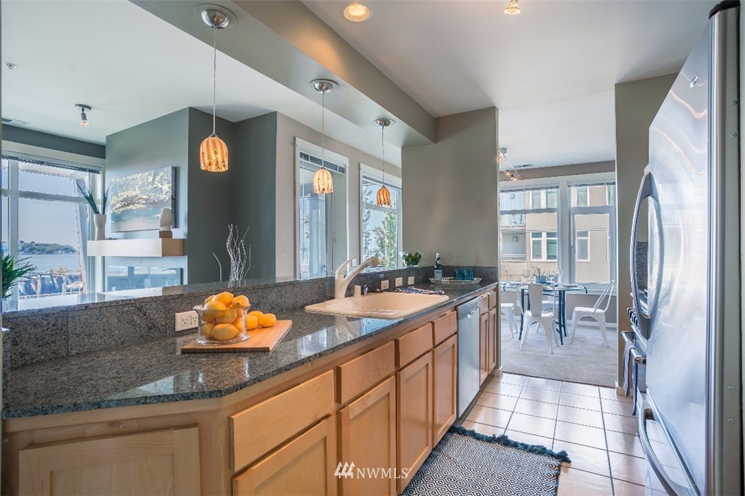 2000 Alaskan Way, Unit 257 Seattle, WA 98121 - Photo 9 of 25 a kitchen with stainless steel appliances granite countertop a sink and a refrigerator