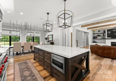 a large kitchen with stainless steel appliances kitchen island granite countertop a table and chairs in it
