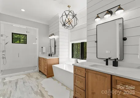 a bathroom with a double vanity sink a mirror and a bathtub