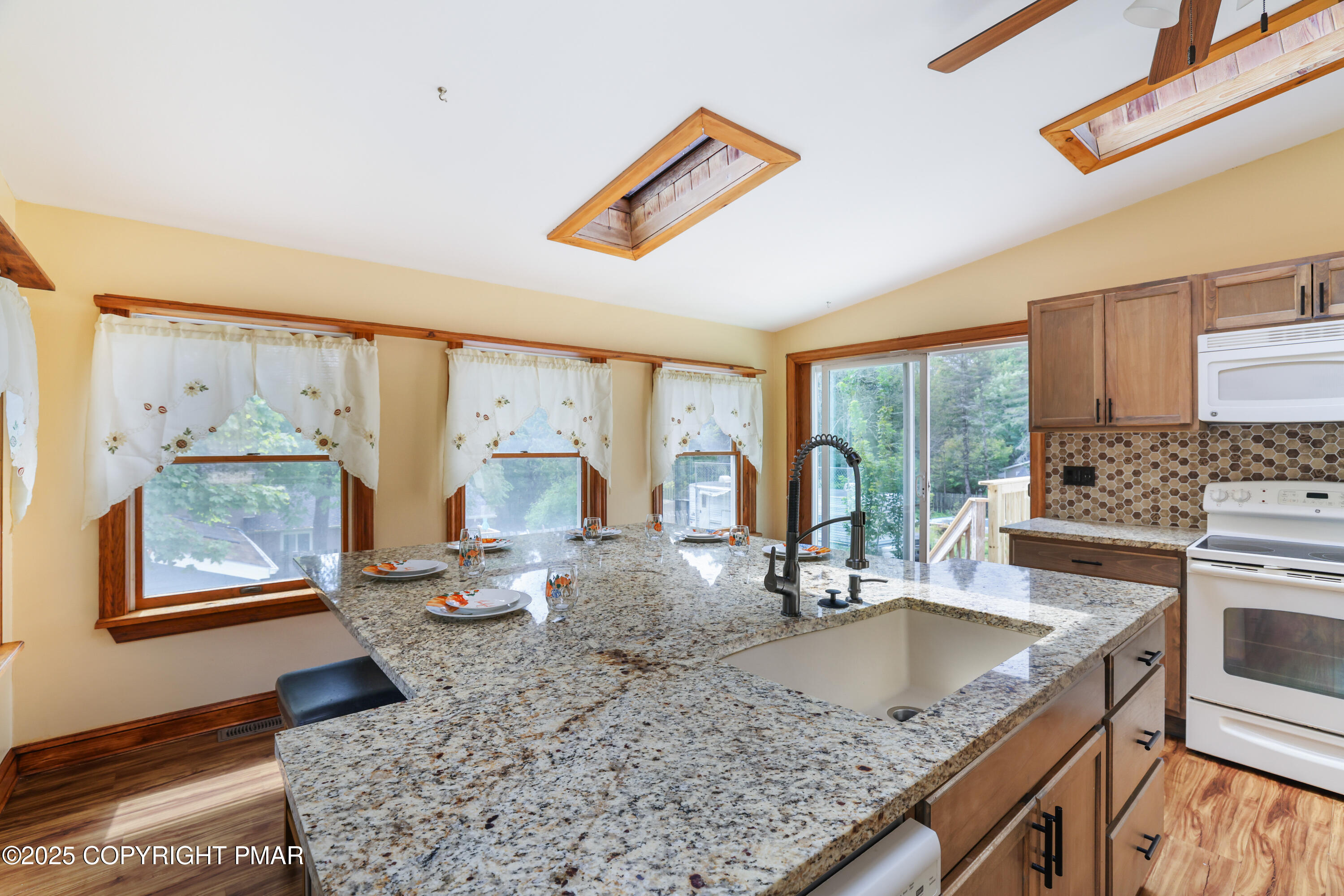 29 Reeder Street Mount Pocono, PA 18344 - Photo 27 of 50 a kitchen with granite countertop a stove a sink a dining table and chairs