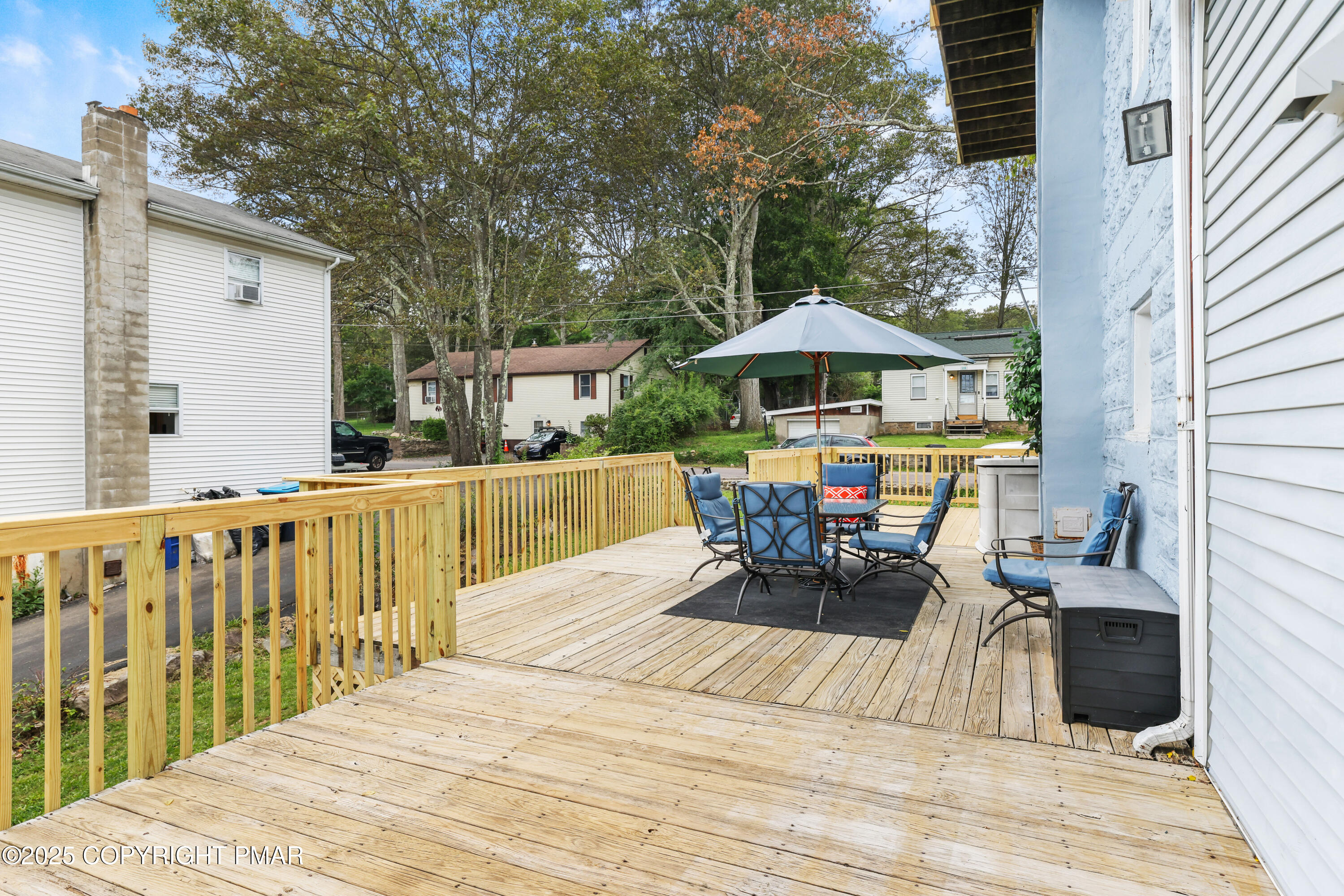 29 Reeder Street Mount Pocono, PA 18344 - Photo 43 of 50 a view of a roof deck with table and chairs under an umbrella with wooden floor