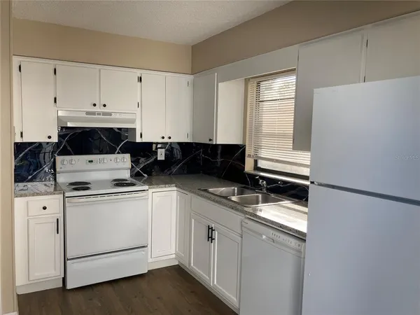 a white refrigerator freezer sitting inside of a kitchen