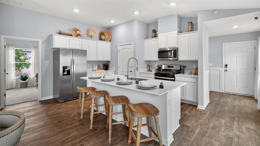 34 Divot Place Bunnell, FL 32110 - Photo 6 of 51 a kitchen with stainless steel appliances a dining table chairs refrigerator and sink