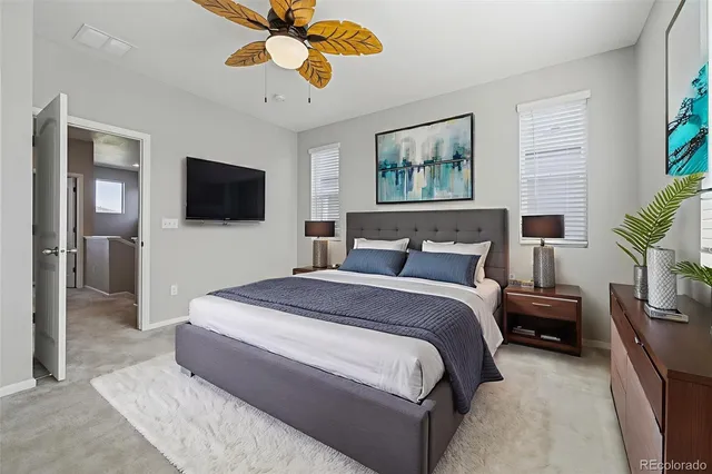 a spacious bedroom with a bed and a flat screen tv