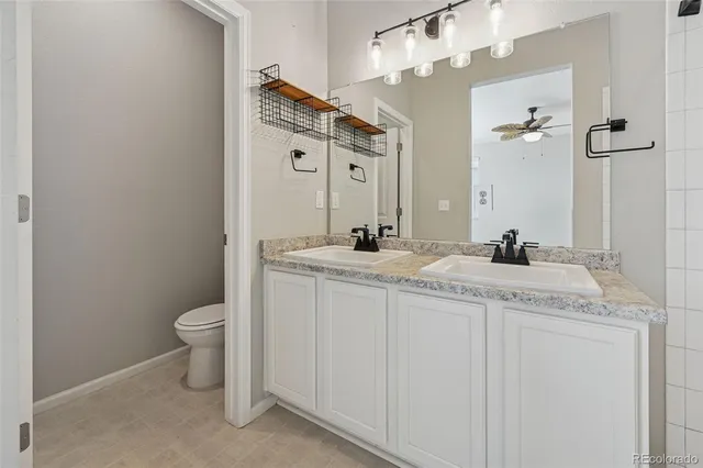 a bathroom with a granite countertop sink a toilet and a mirror