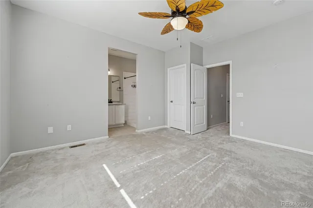 an empty room with closet and windows