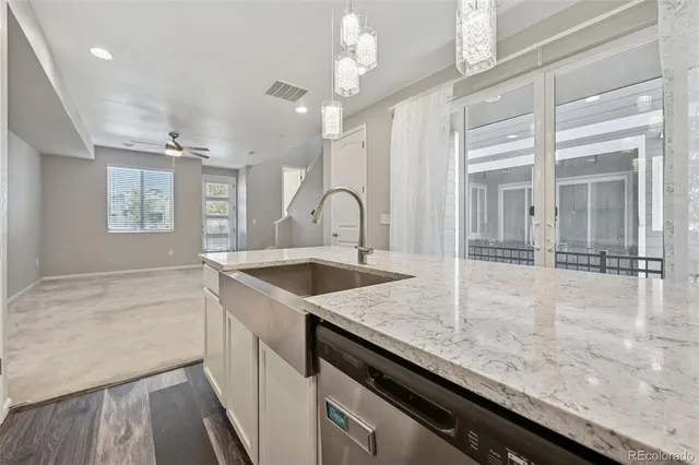 a kitchen with granite countertop a sink a counter top space and cabinets