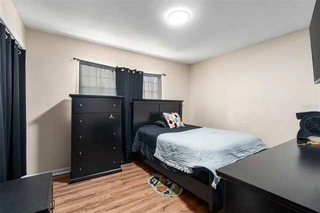 a bedroom with a bed and wooden floor