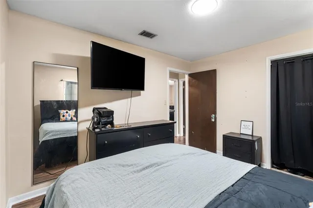 a bedroom with a bed and a flat screen tv