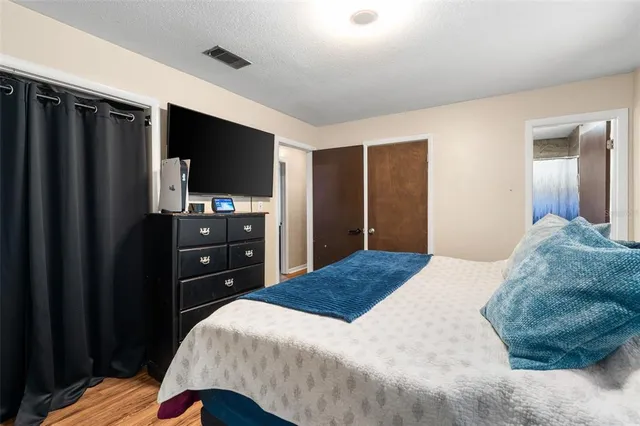 a bedroom with a bed and a flat screen tv