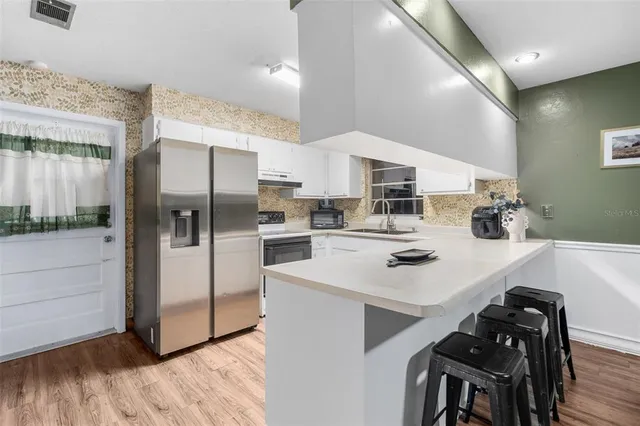 a kitchen with stainless steel appliances a sink a stove a refrigerator and cabinets