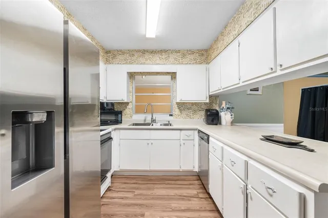 a kitchen with white cabinets and white appliances