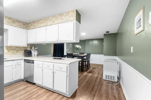a kitchen with a sink cabinets and wooden floor