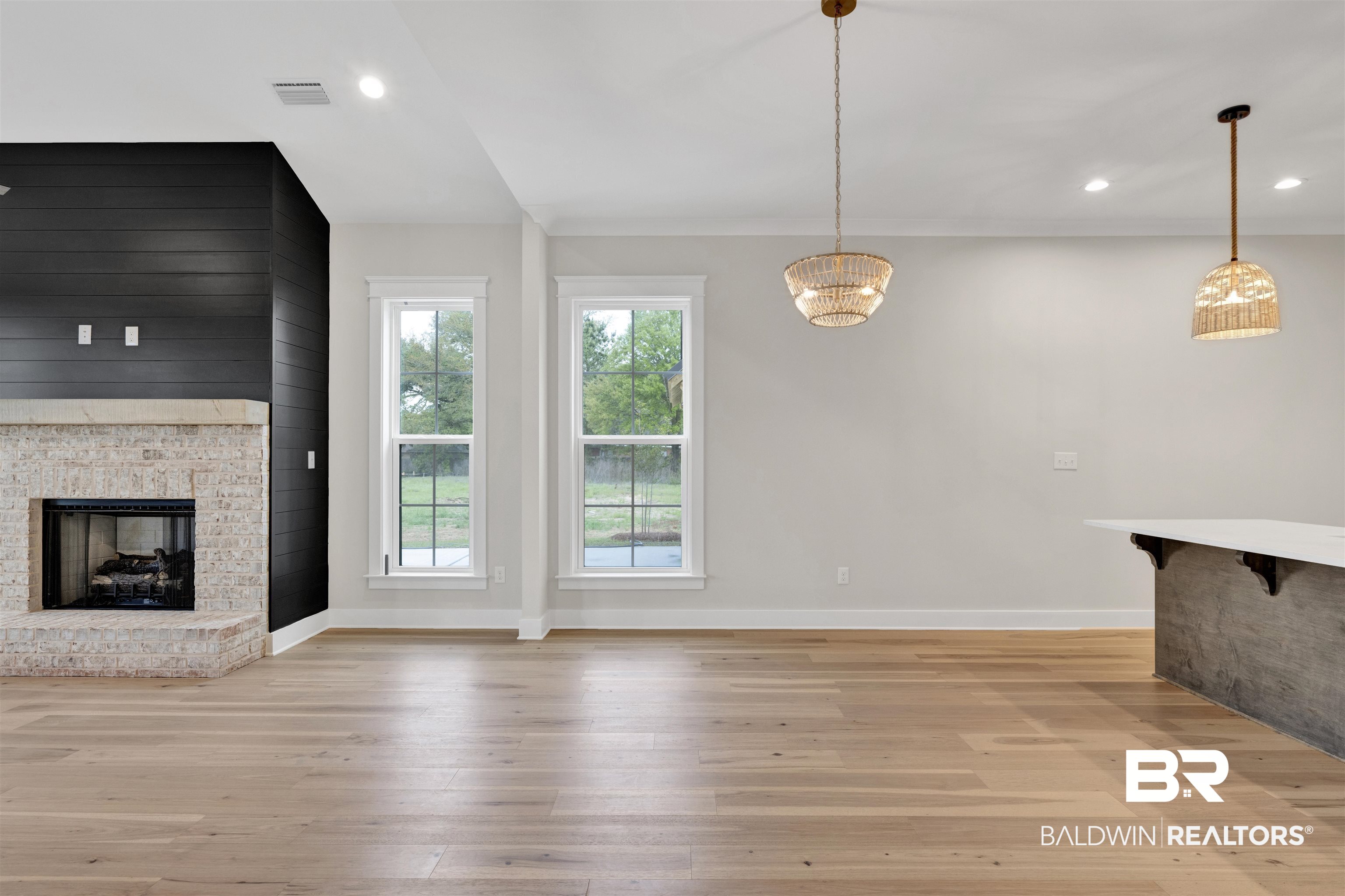 27382 Patch Pl Loop Daphne, AL 36526 - Photo 11 of 31 Unfurnished living room featuring a fireplace, light wood-style flooring, suspended lighting, and wood walls