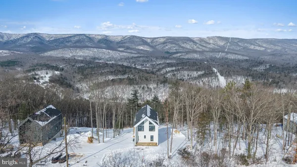 a front view of a house with a yard and mountain view