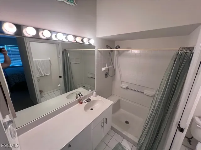 a bathroom with a sink mirror and a shower