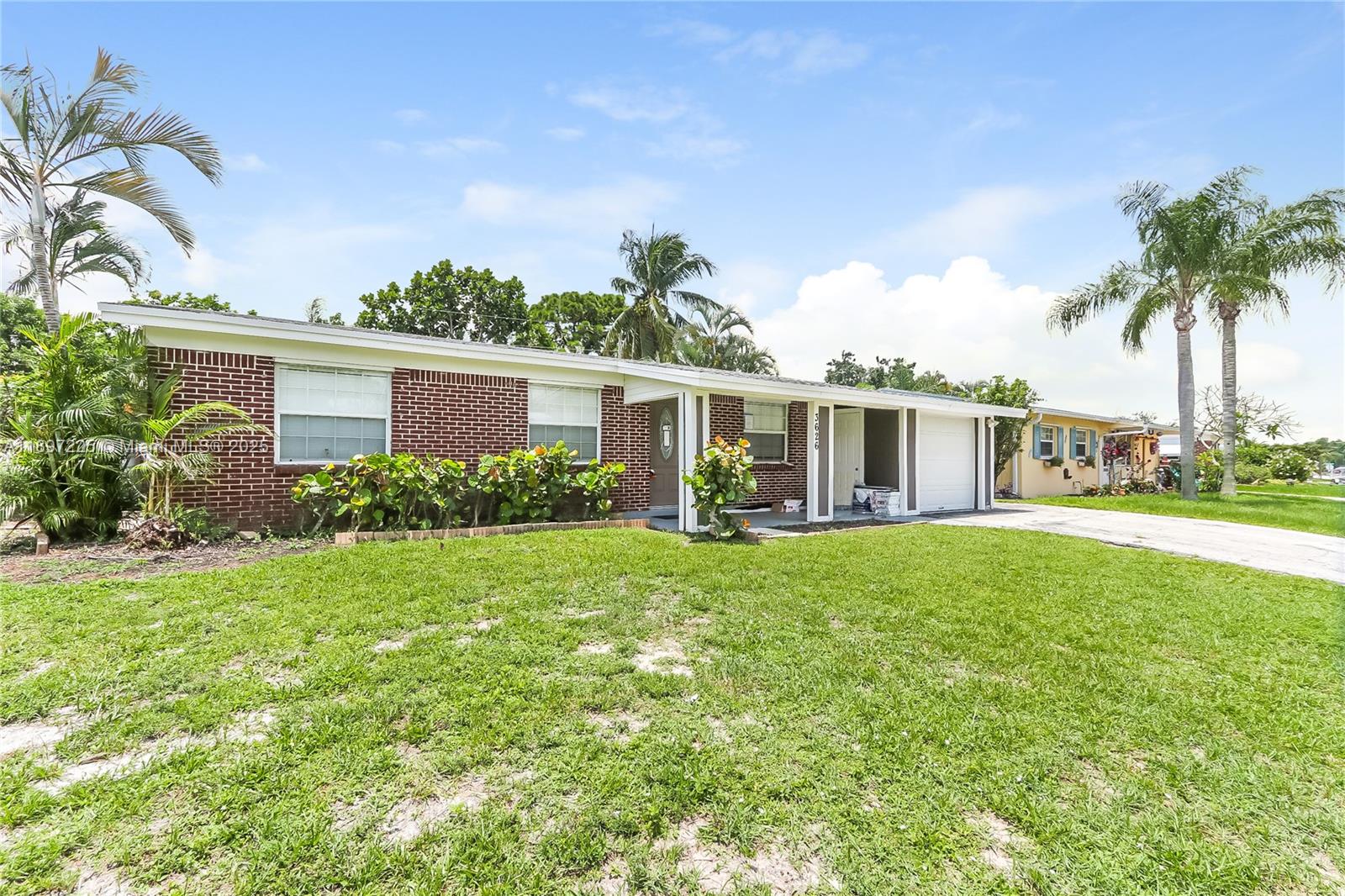 3626 Everglades Road Palm Beach Gardens, FL 33410 - Photo 3 of 16 a front view of a house with garden