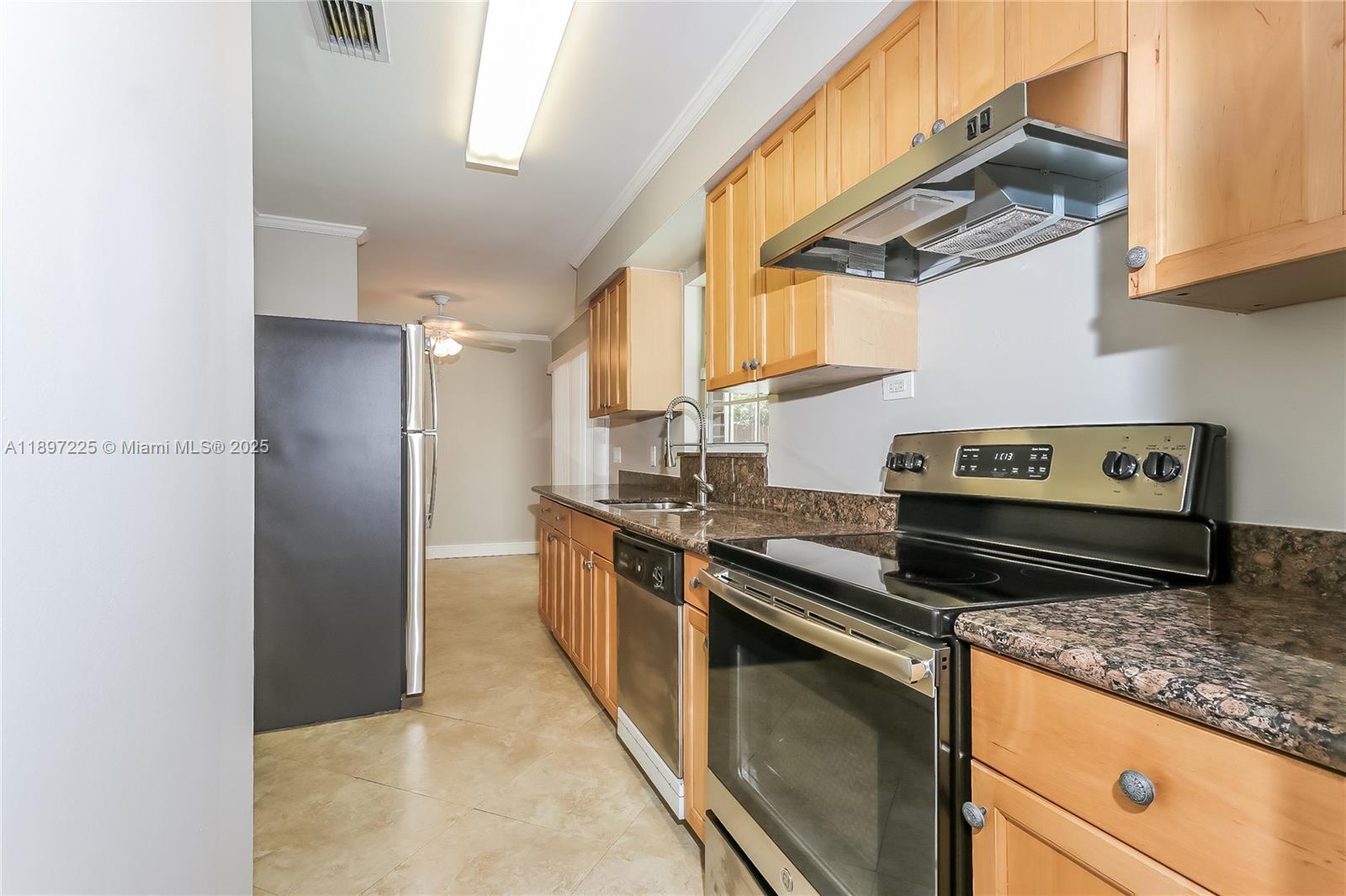 3626 Everglades Road Palm Beach Gardens, FL 33410 - Photo 7 of 16 a kitchen with stainless steel appliances granite countertop a stove a sink and a refrigerator