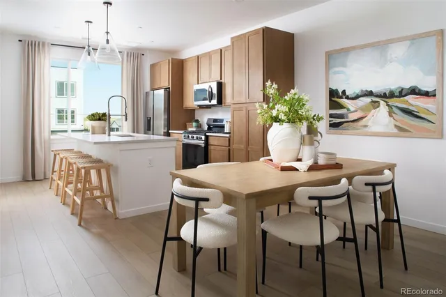 a kitchen with stainless steel appliances a dining table chairs and granite counter tops