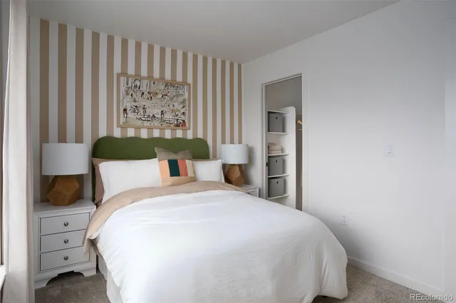 a large bed sitting in a bedroom next to a window