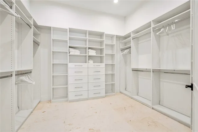 a view of walk in closet with empty racks