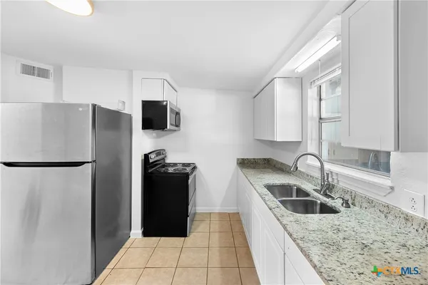 a kitchen with a refrigerator and a sink