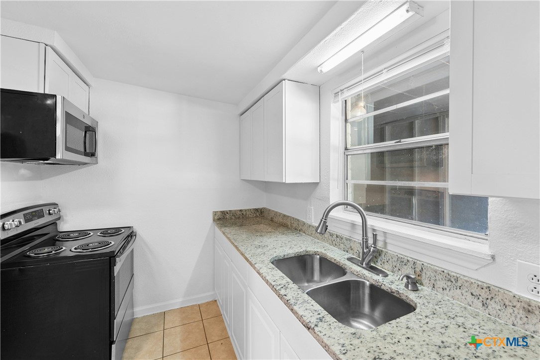 1007 Hackberry Street San Marcos, TX 78666 - Photo 12 of 36 a kitchen with stainless steel appliances granite countertop a sink and a stove