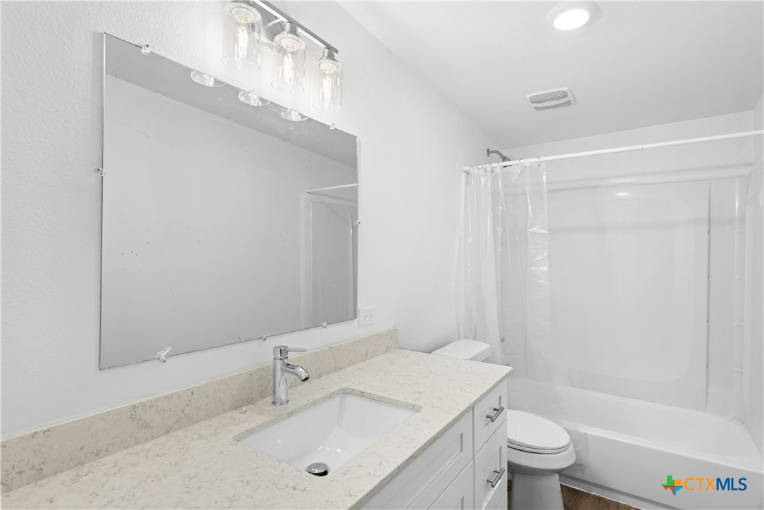 1007 Hackberry Street San Marcos, TX 78666 - Photo 22 of 36 a bathroom with a sink a toilet and shower