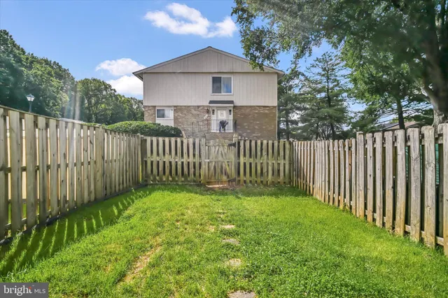 a view of a brick house with a yard and large windows