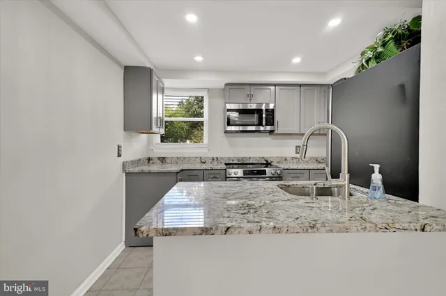 a kitchen with sink a stove and cabinets