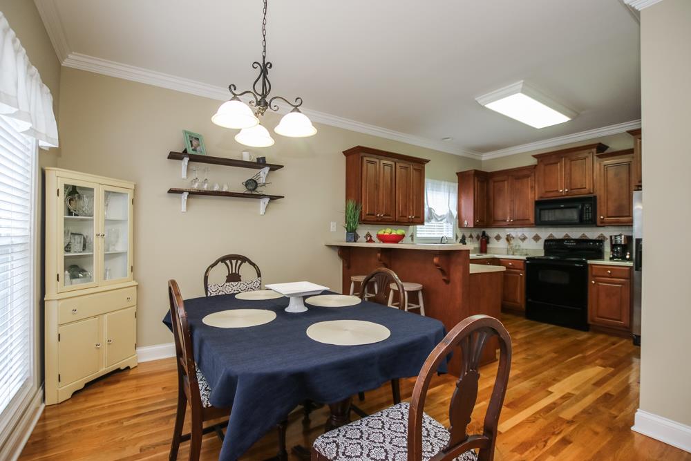 605 Lee Road Lebanon, TN 37087 - Photo 7 of 30 a kitchen with a refrigerator a stove a kitchen island and chairs with wooden floor